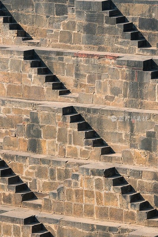 印度拉贾斯坦邦Abhaneri Chand Baori阶梯井的石楼梯背景透视图。梯级井，通过一组梯级下降到水平面到达水的井